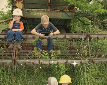 Two young boys in a rural area using handheld devices
