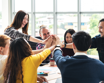 Happy office workers giving a group high five