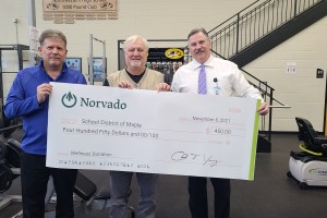 norvado employees present check to maple school district